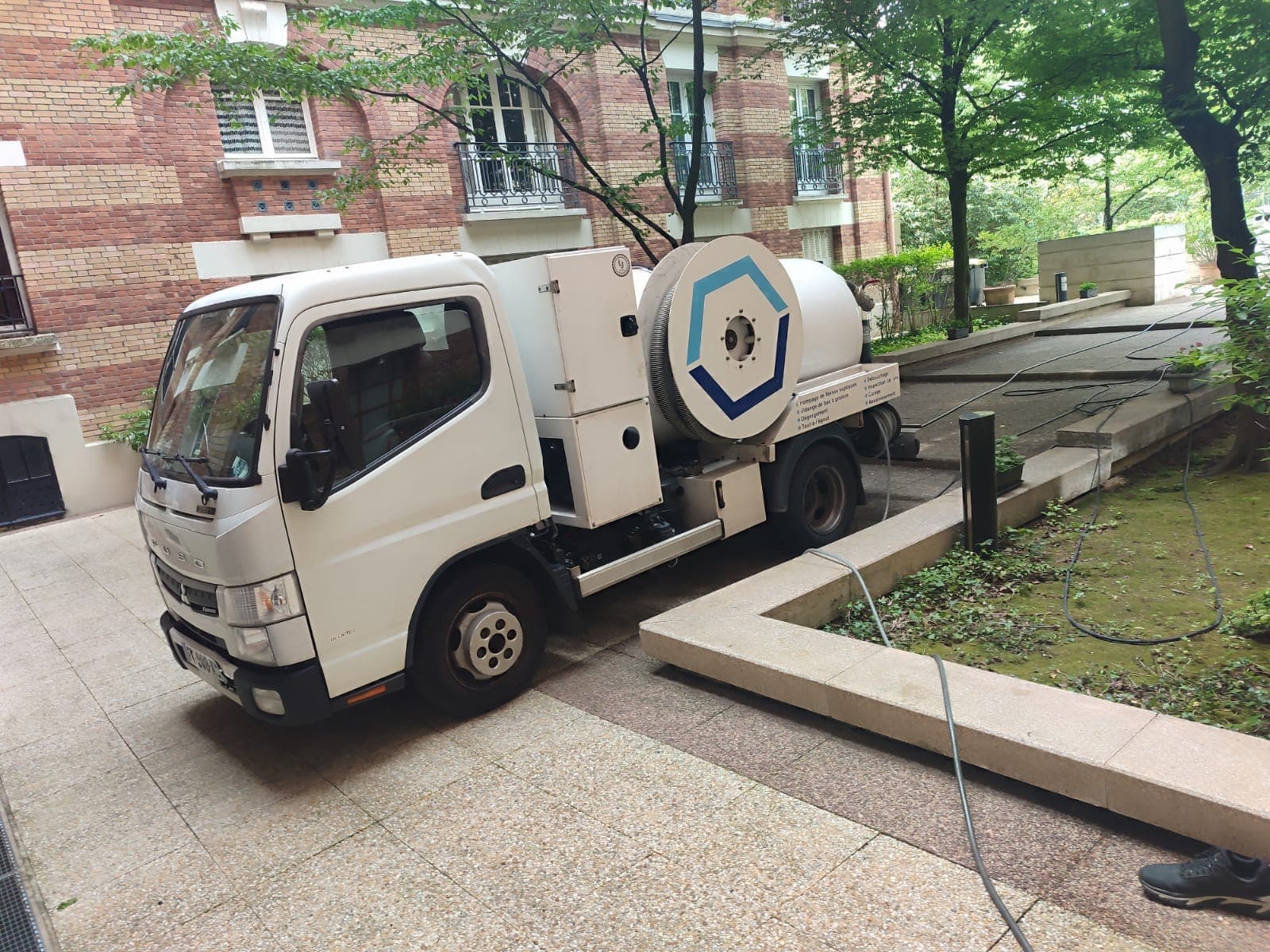 Camion hydrocureur AD Service IDF en intervention devant une copropriété